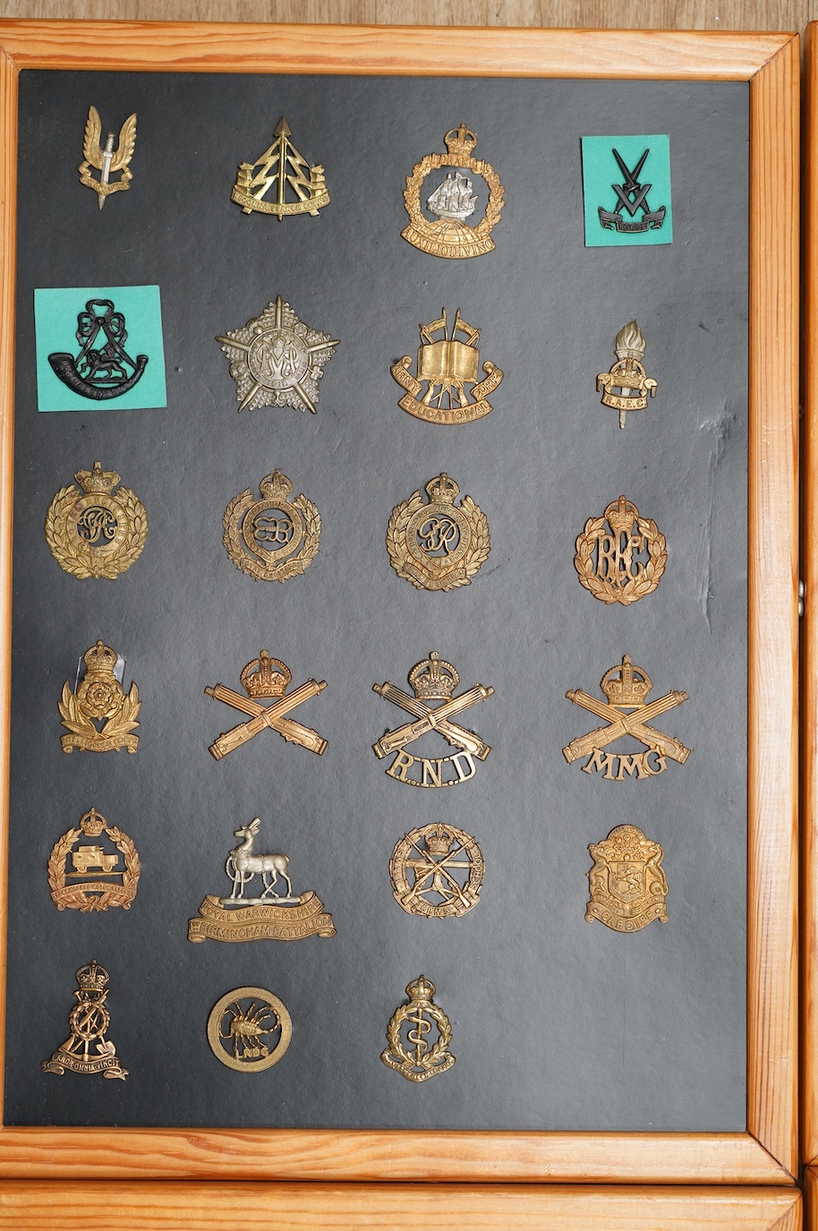 A collection of ninety-five military cap badges mounted on four boards including; The Reconnaissance Corps, RAEC, Royal Engineers, Small Arms School, Royal Warwickshire 1st Birmingham Battalion, Royal Army Medical Corps,